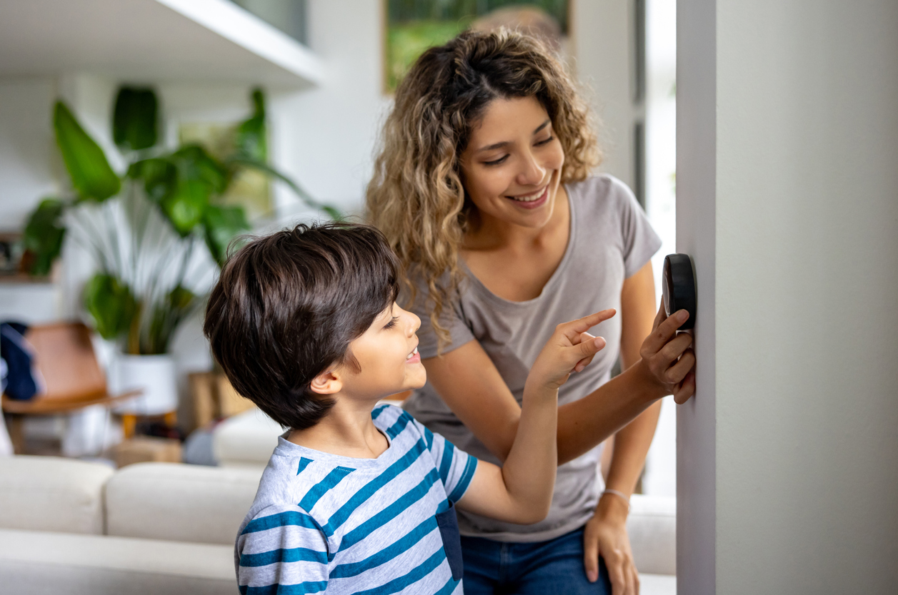 Woman and Boy Adjusting Thermostat